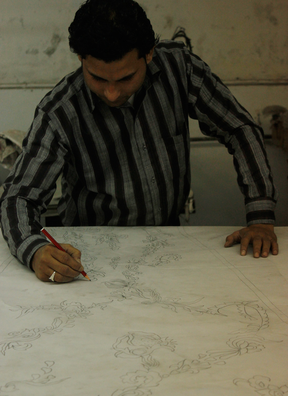 Our head designer traces the images to prepare them for hand embroidery.