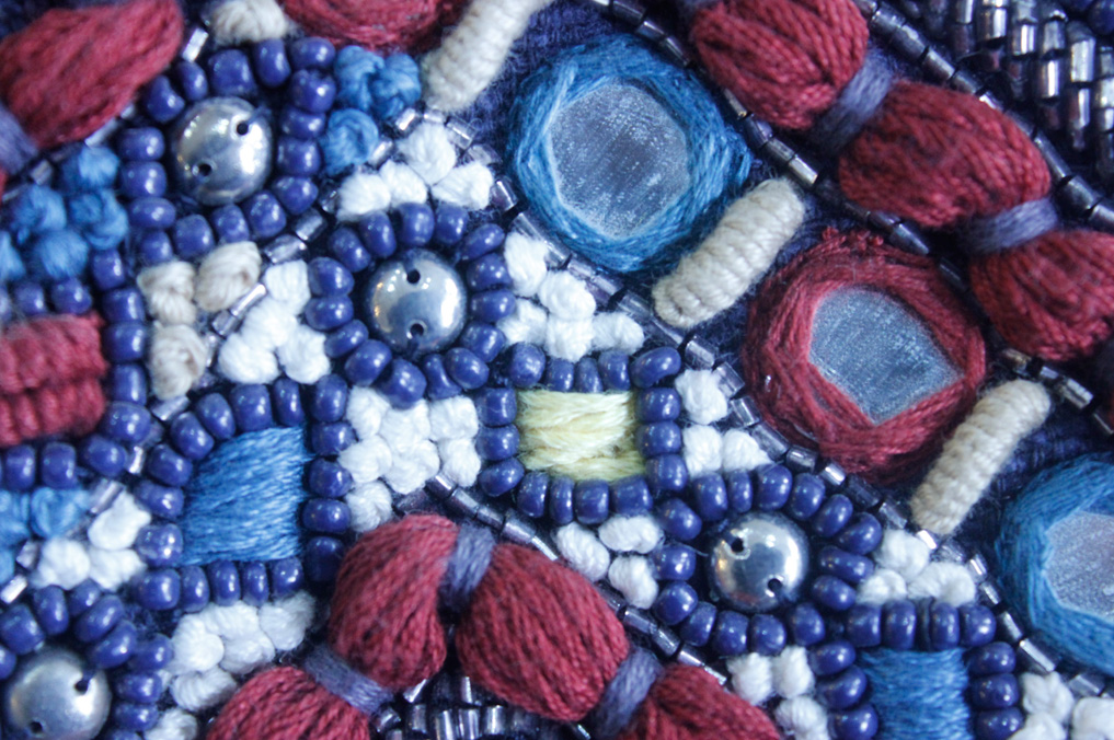 French knots hand embroidered with mirrors and beads in thick cotton thread.